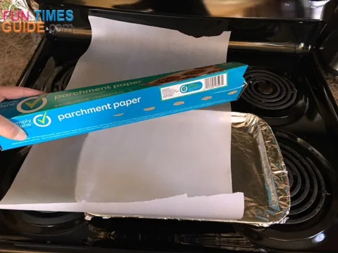 Unroll a double length of parchment paper to cover the base of the cookie sheet AND the bacon strips.