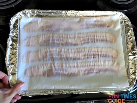 Place the baking sheet with bacon on it into the oven.