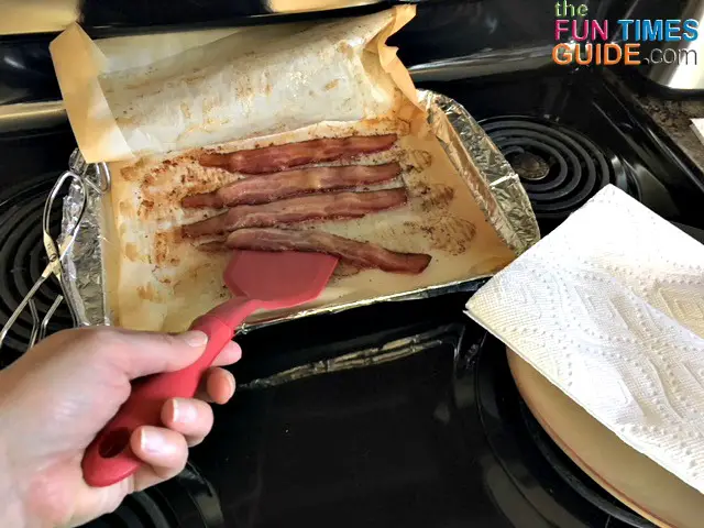 Use a spatula or tongs to remove the cooked bacon from the baking sheet.
